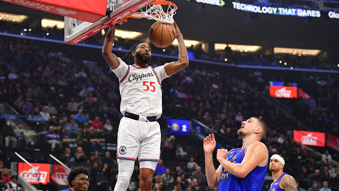 Dec 1, 2024; Inglewood, California, USA; Los Angeles Clippers forward Derrick Jones Jr. (55) dunks for the basket against Denver Nuggets center Nikola Jokic (15) during the first half at Intuit Dome. Mandatory Credit: Gary A. Vasquez-Imagn Images