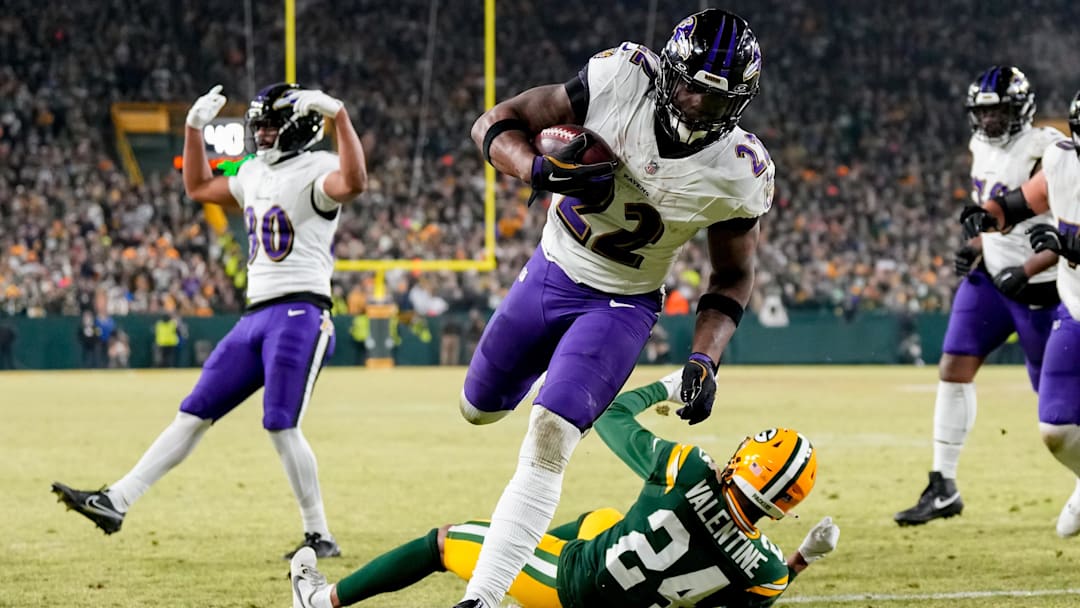 Dec 27, 2025; Green Bay, Wisconsin, USA; Baltimore Ravens running back Derrick Henry (22) runs for a touchdown past Green Bay Packers cornerback Carrington Valentine (24) during the second quarter at Lambeau Field. Mandatory Credit: Jeff Hanisch-Imagn Images