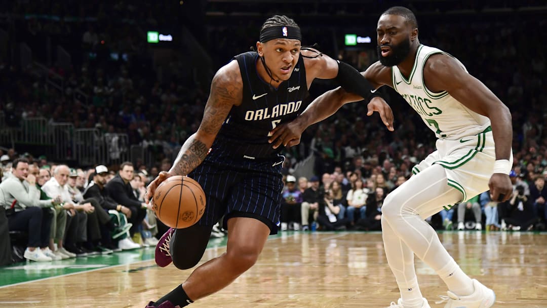 Apr 20, 2025; Boston, Massachusetts, USA: Orlando Magic forward Paolo Banchero (5) controls the ball while Boston Celtics guard Jaylen Brown (7) defends during the first half at TD Garden. Mandatory Credit: Bob DeChiara-Imagn Images
