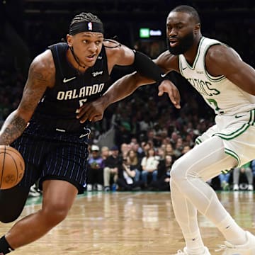 Apr 20, 2025; Boston, Massachusetts, USA: Orlando Magic forward Paolo Banchero (5) controls the ball while Boston Celtics guard Jaylen Brown (7) defends during the first half at TD Garden. Mandatory Credit: Bob DeChiara-Imagn Images