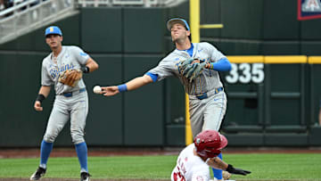 Jun 17, 2025; Omaha, Neb, USA;  UCLA Bruins shortstop Roch Cholowsky (1) completes a double play after getting Arkansas Razorbacks designated hitter Kuhio Aloy (25) out during the first inning at Charles Schwab Field. Mandatory Credit: Steven Branscombe-Imagn Images