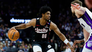 Mar 27, 2025; Sacramento, California, USA; Portland Trail Blazers guard Scoot Henderson (00) dribbles against Sacramento Kings forward Domantas Sabonis (11) during the third quarter at Golden 1 Center. Mandatory Credit: Sergio Estrada-Imagn Images