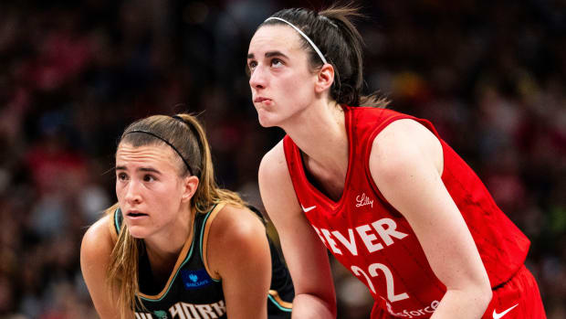 New York Liberty guard Sabrina Ionescu and Indiana Fever guard Caitlin Clark watch a free throw at Gainbridge Fieldhouse.
