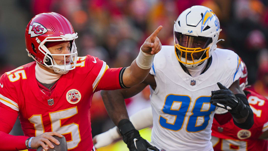 Dec 14, 2025; Kansas City, Missouri, USA; Kansas City Chiefs quarterback Patrick Mahomes (15) scrambles against Los Angeles Chargers linebacker Odafe Oweh (98) during the second half at GEHA Field at Arrowhead Stadium. Mandatory Credit: Jay Biggerstaff-Imagn Images