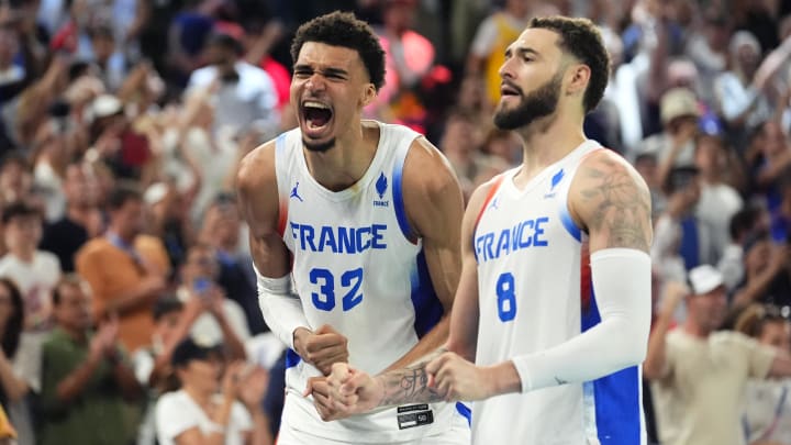 Aug 8, 2024; Paris, France; France power forward Victor Wembanyama (32) celebrates alongside shooting guard Isaia Cordinier (8) during the second half against Germany in a men's basketball semifinal game during the Paris 2024 Olympic Summer Games at Accor Arena. 