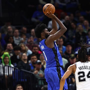 Feb 8, 2024; Orlando, Florida, USA; Orlando Magic forward Jonathan Isaac (1)makes a basket over San Antonio Spurs guard Devin Vassell (24) and San Antonio Spurs forward Keldon Johnson (3)  during the second half at Kia Center. Mandatory Credit: Kim Klement Neitzel-Imagn Images