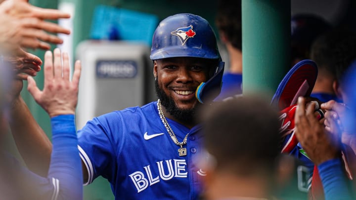 Aug 26, 2024; Boston, Massachusetts, USA; Toronto Blue Jays first baseman Vladimir Guerrero Jr. (27) is congratulated after scoring against the Boston Red Sox in the eighth inning at Fenway Park. Mandatory Credit: David Butler II-USA TODAY Sports