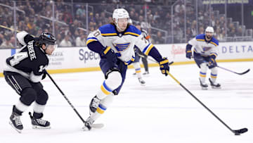 Mar 8, 2025; Los Angeles, California, USA; St. Louis Blues center Oskar Sundqvist (70) moves the puck against Los Angeles Kings right wing Alex Laferriere (14) during the first period at Crypto.com Arena. Mandatory Credit: Ryan Sun-Imagn Images