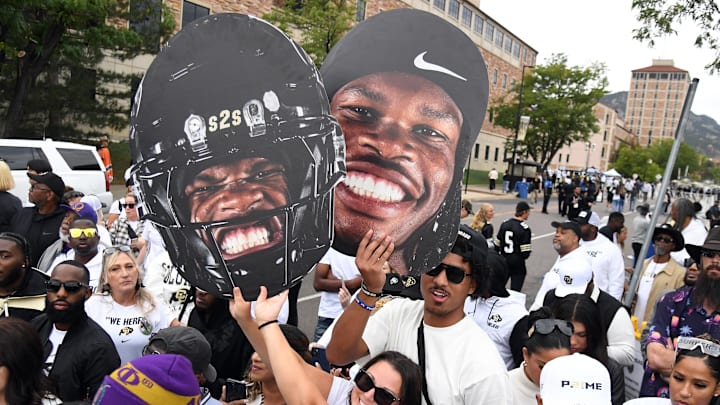 Colorado Buffaloes fans hold signs for quarterback Shedeur Sanders (2) and wide receiver Travis Hunter
