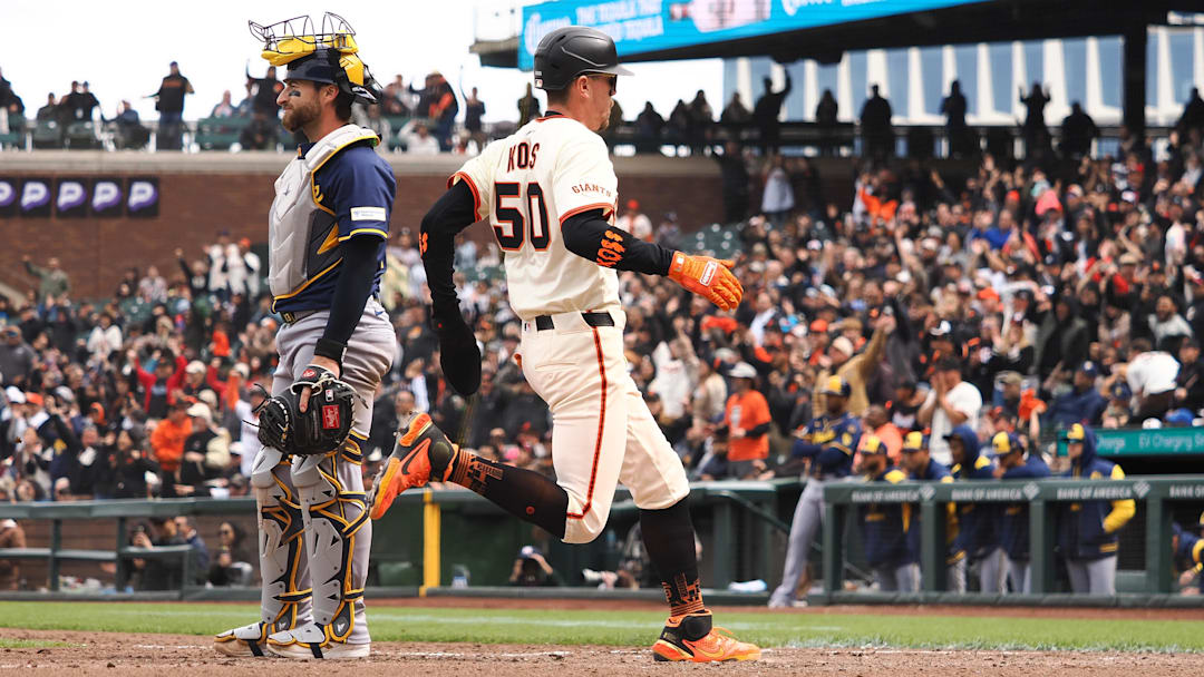 Apr 24, 2025; San Francisco, California, USA; San Francisco Giants pinch runner Christian Koss (50) scores a run against Milwaukee Brewers catcher Eric Haase (13) during the eighth inning at Oracle Park. Mandatory Credit: Kelley L Cox-Imagn Images