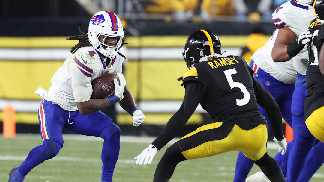 Nov 30, 2025; Pittsburgh, Pennsylvania, USA; Buffalo Bills running back James Cook III (4) rushes as Pittsburgh Steelers cornerback Jalen Ramsey (5) defends during the fourth quarter at Acrisure Stadium. Mandatory Credit: Charles LeClaire-Imagn Images