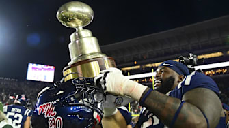 Mississippi players celebrate with the Egg Bowl trophy after the beating rival Mississippi State last season.