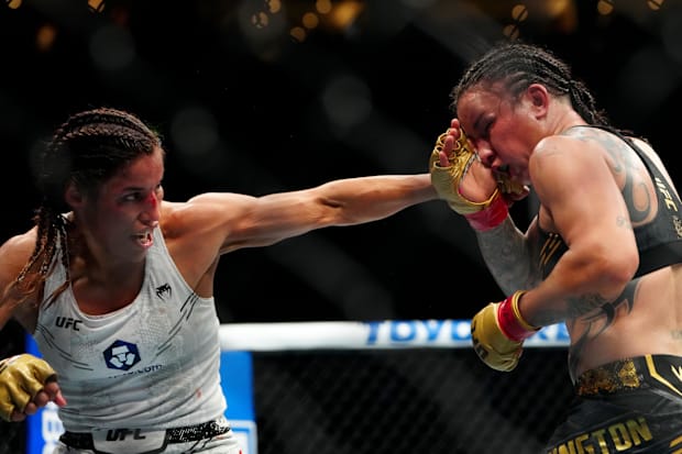 Raquel Pennington (red gloves) fights Julianna Pena (blue gloves) in a women’s bantamweight title bout during UFC 307 at Delt