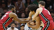 Nov 26, 2025; Miami, Florida, USA; Miami Heat guard Dru Smith (12) and guard Pelle Larsson (9) fight with Milwaukee Bucks center Jericho Sims (00) for a loose ball during the second half of an NBA Cup game at Kaseya Center. Mandatory Credit: Rhona Wise-Imagn Images