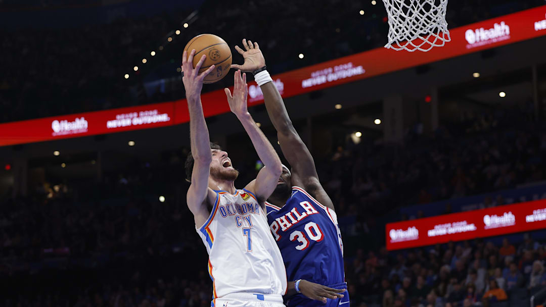 Dec 28, 2025; Oklahoma City, Oklahoma, USA; Oklahoma City Thunder center Chet Holmgren (7) goes up for a basket beside Philadelphia 76ers center Adem Bona (30) during the second half at Paycom Center. Mandatory Credit: Alonzo Adams-Imagn Images