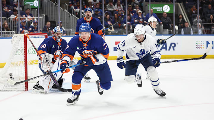 Apr 9, 2026; Elmont, New York, USA;  New York Islanders defenseman Tony DeAngelo (77) and Toronto Maple Leafs center Calle Jarnkrok (19) chase after the puck in the third period at UBS Arena. Mandatory Credit: Wendell Cruz-Imagn Images