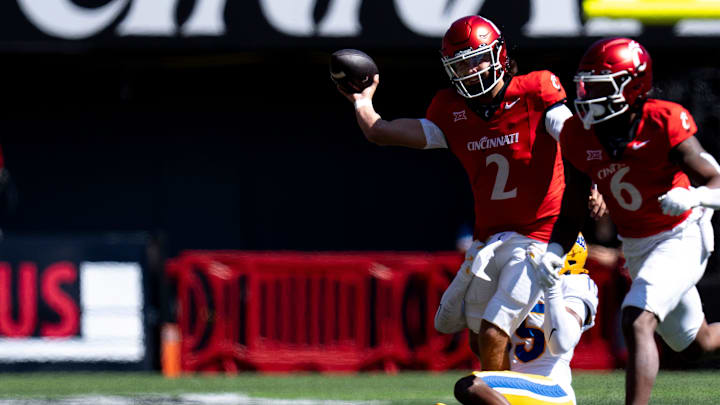 Cincinnati Bearcats quarterback Brendan Sorsby (2) throws a pass as Pittsburgh Panthers defensive back Rashad Battle (15) tackles him in the first quarter of the College Football game between the Cincinnati Bearcats and the Pittsburgh Panthers at Nippert Stadium in Cincinnati on Saturday, Sept. 7, 2024.