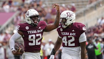 Sep 6, 2025; College Station, Texas, USA; Texas A&M Aggies defensive end Sam M'Pemba (92) and Texas A&M Aggies defensive end Kendall Jackson (42) celebrate after a recovered fumble during the second half against the Utah State Aggies at Kyle Field. Mandatory Credit: Sean Thomas-Imagn Images
