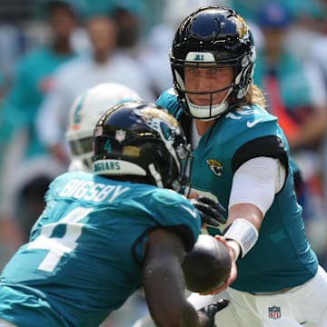 Sep 8, 2024; Miami Gardens, Florida, USA;  Jacksonville Jaguars quarterback Trevor Lawrence (16) hands off to running back Tank Bigsby (4) during the third quarter against the Miami Dolphins at Hard Rock Stadium. Mandatory Credit: Jim Rassol-Imagn Images