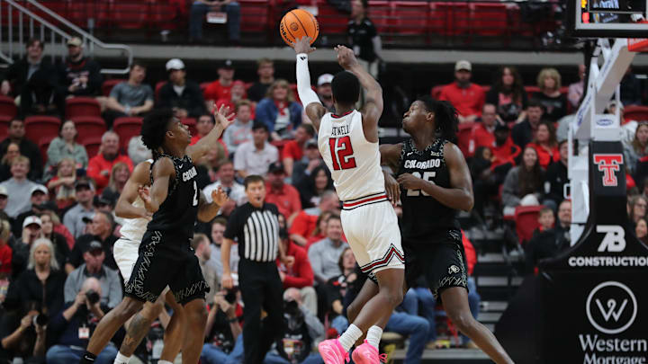 Feb 11, 2026; Lubbock, Texas, USA;  Texas Tech Red Raiders guard Donovan Atwell (12) passes the ball in front of Colorado Buffaloes center Fawaz Ifaola (25) in the second half at United Supermarkets Arena. Mandatory Credit: Michael C. Johnson-Imagn Images
