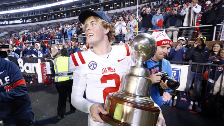 Nov 23, 2023; Starkville, Mississippi, USA; Mississippi Rebels quarterback Jaxson Dart (2) holds the Egg Bowl trophy after defeating the Mississippi State Bulldogs at Davis Wade Stadium at Scott Field. Mandatory Credit: Petre Thomas-USA TODAY Sports