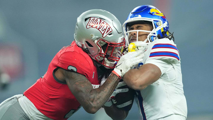 UNLV Rebels defensive back Johnathan Baldwin (3) tackles Kansas Jayhawks wide receiver Trevor Wilson (7) during the first half at Chase Field. UNLV Rebels defensive back Johnathan Baldwin (3) tackles Kansas Jayhawks wide receiver Trevor Wilson (7) during the first half at Chase Field.