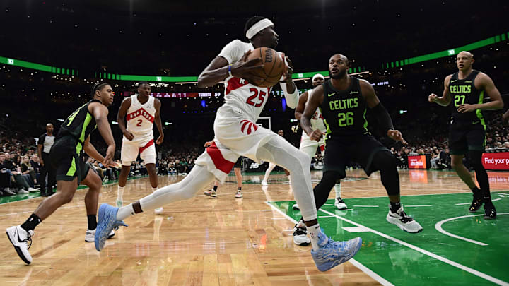 Dec 31, 2024; Boston, Massachusetts, USA;  Toronto Raptors forward Chris Boucher (25) controls the ball while Boston Celtics forward Xavier Tillman (26) defends during the second half at TD Garden. Mandatory Credit: Bob DeChiara-Imagn Images