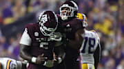 Texas A&M Aggies defensive tackle DJ Hicks celebrates with defensive tackle Tyler Onyedim  after a play during the second half against the Louisiana State Tigers at Tiger Stadium. 