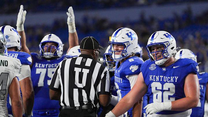 As Kentucky Wildcats offensive lineman Joshua Braun (75) signals touchdown, Kentucky Wildcats quarterback Cutter Boley (8) and Kentucky Wildcats offensive lineman Jager Burton (62) smile as the Cats roll past Eastern Michigan 48-23 at Kroger Field in Lexington, Kentucky Saturday, Sept. 13, 2025.