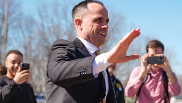 Iowa's new head men's basketball coach Ben McCollum waves at the assembled crowd while walking into his introductory press conference Tuesday, March 25, 2025 at Carver-Hawkeye Arena in Iowa City, Iowa.