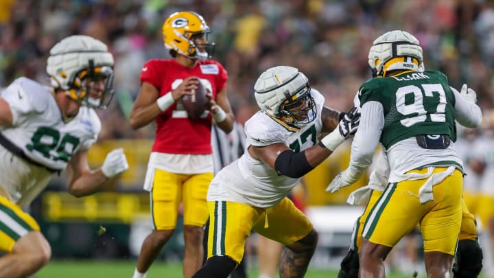 Green Bay Packers lineman Jordan Morgan (77) blocks defensive lineman Kenny Clark (97) to protect Jordan Love at Family Night.