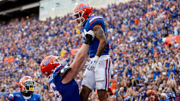 Florida Gators offensive lineman Jake Slaughter (66) holds up Florida Gators wide receiver Eugene Wilson III (3) after a touchdown during the second half at Steve Spurrier Field at Ben Hill Griffin Stadium in Gainesville, FL on Saturday, October 7, 2023. [Matt Pendleton/Gainesville Sun]