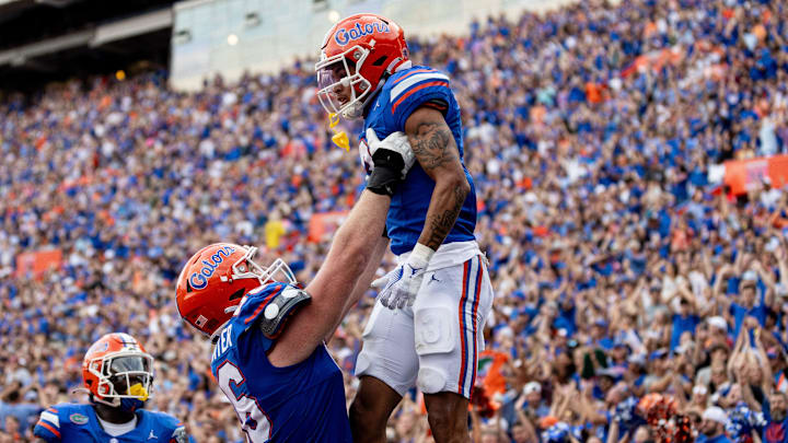 Florida Gators offensive lineman Jake Slaughter (66) holds up Florida Gators wide receiver Eugene Wilson III (3) after a touchdown during the second half at Steve Spurrier Field at Ben Hill Griffin Stadium in Gainesville, FL on Saturday, October 7, 2023. [Matt Pendleton/Gainesville Sun]