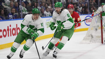 Mar 17, 2025; Toronto, Ontario, CAN; Toronto Maple Leafs forward Max Domi (11) gets control of the puck as  defenceman Chris Tanev (8) blocks out Calgary Flames forward Blake Coleman (20) during the second period at Scotiabank Arena. Mandatory Credit: John E. Sokolowski-Imagn Images