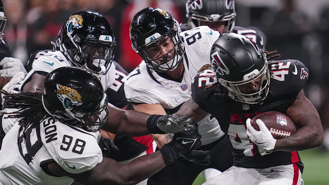 Aug 23, 2024; Atlanta, Georgia, USA; Atlanta Falcons running back Spencer Brown (42) is tackled by Jacksonville Jaguars defensive tackle Jordan Jefferson (98) and defensive end Joe Gaziano (97) during the second half at Mercedes-Benz Stadium. Mandatory Credit: Dale Zanine-Imagn Images