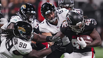 Aug 23, 2024; Atlanta, Georgia, USA; Atlanta Falcons running back Spencer Brown (42) is tackled by Jacksonville Jaguars defensive tackle Jordan Jefferson (98) and defensive end Joe Gaziano (97) during the second half at Mercedes-Benz Stadium. Mandatory Credit: Dale Zanine-Imagn Images