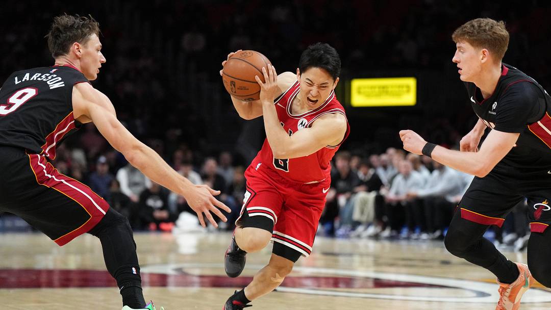 Feb 1, 2026; Miami, Florida, USA; Chicago Bulls guard Yuki Kawamura (8) splits the defense of Miami Heat guard Pelle Larsson (9) and Kasparas Jakucionis (25) during the first half at Kaseya Center. Mandatory Credit: Jim Rassol-Imagn Images