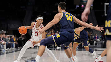 Dec 18, 2024; Charlotte, North Carolina, USA; Oklahoma Sooners guard Jeremiah Fears (0) tries to get past Michigan Wolverines center Vladislav Goldin (50) during the first half at Spectrum Center. Mandatory Credit: Jim Dedmon-Imagn Images