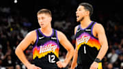 Nov 13, 2025; Phoenix, Arizona, USA;  Phoenix Suns guard Collin Gillespie (12) and Phoenix Suns guard Devin Booker (1) during the first half of the game at Mortgage Matchup Center. Mandatory Credit: Arianna Grainey-Imagn Images