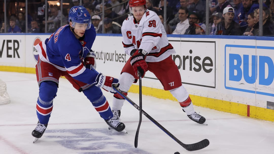 May 13, 2024; New York, New York, USA; New York Rangers defenseman Braden Schneider (4) fights for the puck against Carolina Hurricanes left wing Jake Guentzel (59) during the third period of game five of the second round of the 2024 Stanley Cup Playoffs at Madison Square Garden. Mandatory Credit: Brad Penner-USA TODAY Sports