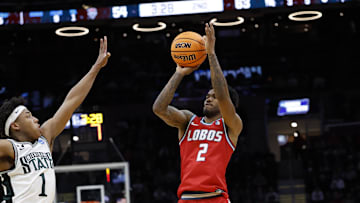 Mar 23, 2025; Cleveland, OH, USA; New Mexico Lobos guard Donovan Dent (2) shoots the ball over Michigan State Spartans guard Jeremy Fears Jr. (1) in the second half during the NCAA Tournament Second Round at Rocket Arena. Mandatory Credit: Rick Osentoski-Imagn Images