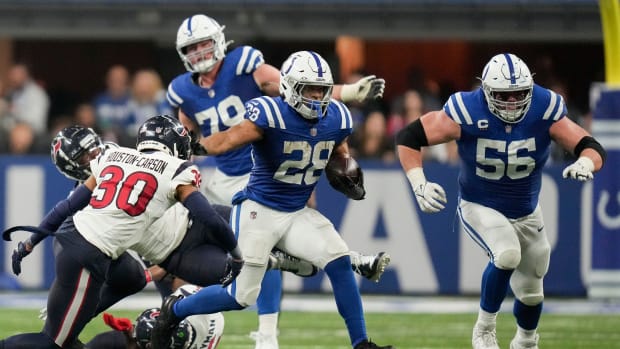 Football player Jonathan Taylor runs with the ball in a blue jersey.