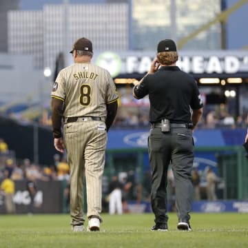 Aug 6, 2024; Pittsburgh, Pennsylvania, USA;  Pittsburgh Pirates manager Derek Shelton (left) and San Diego Padres manager Mike Shildt (8) walk to the outfield with umpires to assess the condition of the warning track after a heavy rain delayed their game in the second inning at PNC Park. Mandatory Credit: Charles LeClaire-USA TODAY Sports