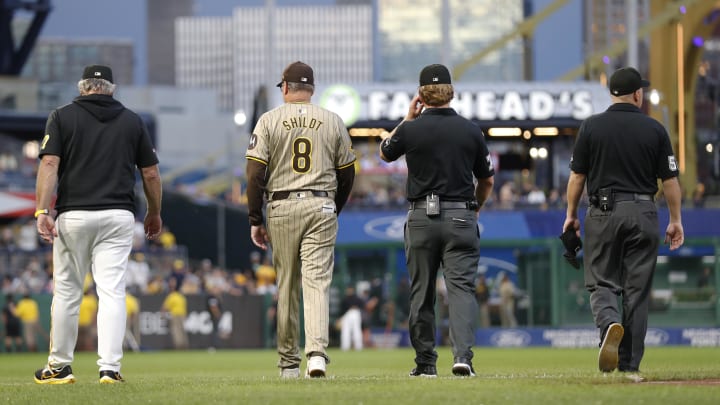 Aug 6, 2024; Pittsburgh, Pennsylvania, USA;  Pittsburgh Pirates manager Derek Shelton (left) and San Diego Padres manager Mike Shildt (8) walk to the outfield with umpires to assess the condition of the warning track after a heavy rain delayed their game in the second inning at PNC Park. Mandatory Credit: Charles LeClaire-USA TODAY Sports