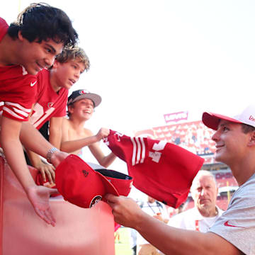 Aug 9, 2025; Santa Clara, California, USA;  San Francisco 49ers quarterback Brock Purdy (13) signs autographs before the game against the Denver Broncos at Levi's Stadium. Mandatory Credit: David Gonzales-Imagn Images