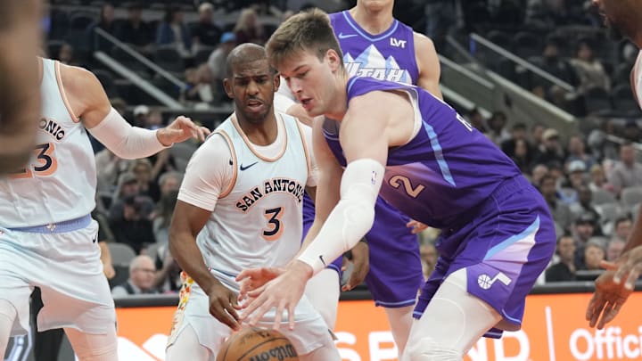 Nov 21, 2024; San Antonio, Texas, USA; Utah Jazz forward Kyle Filipowski (22) reaches for the ball while defended by San Antonio Spurs guard Chris Paul (3) during the first half at Frost Bank Center. Mandatory Credit: Scott Wachter-Imagn Images