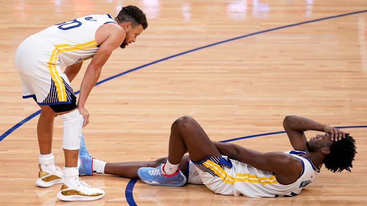 Jan 1, 2021; San Francisco, California, USA; Golden State Warriors center James Wiseman (on floor) reacts after suffering an apparent injury as guard Stephen Curry (30) looks on during the fourth quarter against the Portland Trail Blazers at the Chase Center. Mandatory Credit: Cary Edmondson-Imagn Images