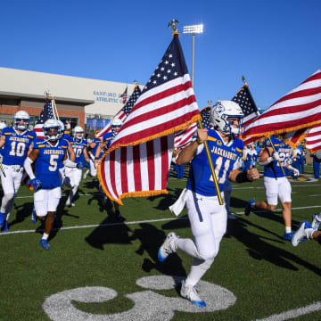 South Dakota State runs onto the field with U.S. flags before the game against Missouri State