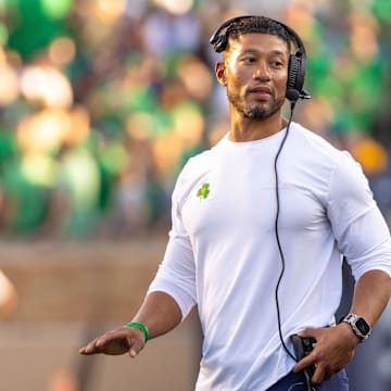 Oct 4, 2025; South Bend, Indiana, USA; Notre Dame head football coach Marcus Freeman adjusts his radio against the Boise State Broncos at Notre Dame Stadium. Mandatory Credit: Michael Caterina-Imagn Images