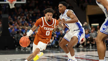 Nov 4, 2025; Charlotte, North Carolina, USA; Texas Longhorns guard Jordan Pope (0) drives the ball around Duke Blue Devils guard Caleb Foster (1) during the second half of the Dick Vitale’s Invitational game at Spectrum Center. Mandatory Credit: Cory Knowlton-Imagn Images